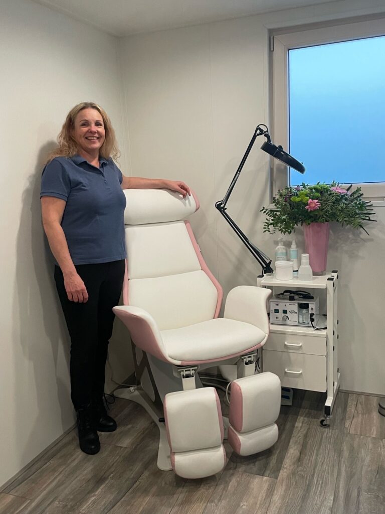 Roelanda Imminga staand in de praktijkruimte bij de pedicure behandelstoel