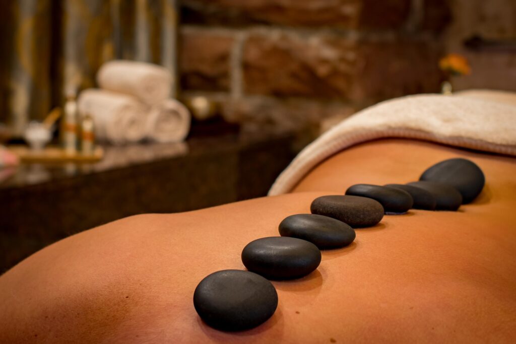 Hotstonemassage met meerdere zwarte hotstones op de rug.